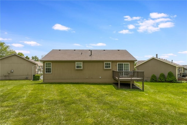 rear view of house featuring a deck and a lawn