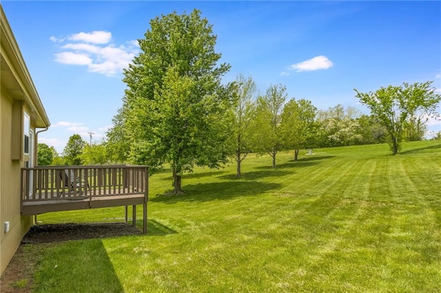 view of grassy yard with a deck