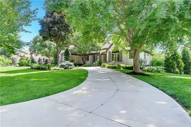 14575 Granada Cir, Leawood, KS 66224 - view of front facade with a front yard, curved driveway, and stucco siding