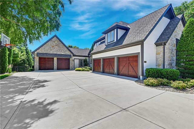 14575 Granada Cir, Leawood, KS 66224 - view of side of home with stone siding, an attached garage, driveway, and stucco siding