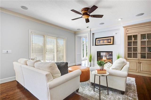 14575 Granada Cir, Leawood, KS 66224 - living room featuring ornamental molding, a glass covered fireplace, ceiling fan, and dark wood-type flooring