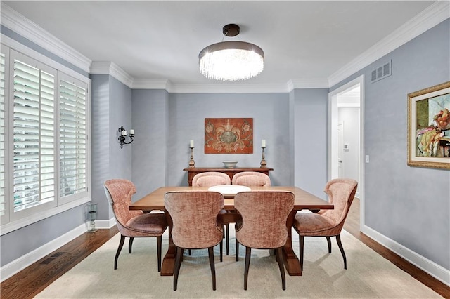 14575 Granada Cir, Leawood, KS 66224 - dining space with wood finished floors, healthy amount of natural light, a chandelier, and crown molding