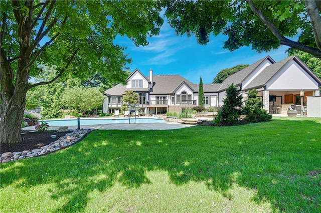 14575 Granada Cir, Leawood, KS 66224 - rear view of house with an outdoor pool and a yard