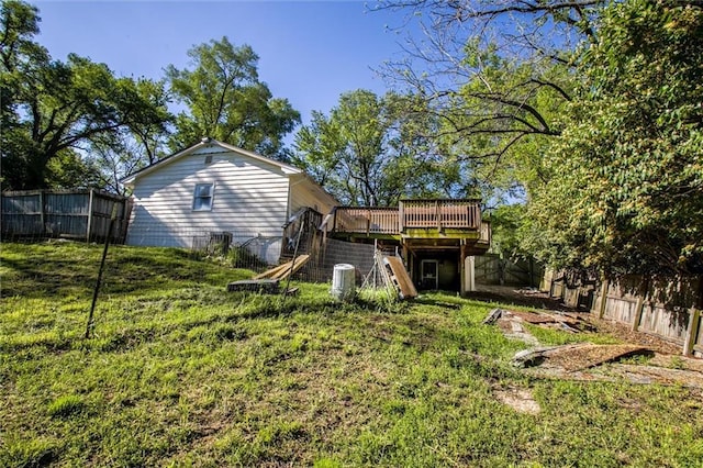 4904 Grandview Rd, Kansas City, MO 64137 - back of house with stairway, a deck, a fenced backyard, and a lawn
