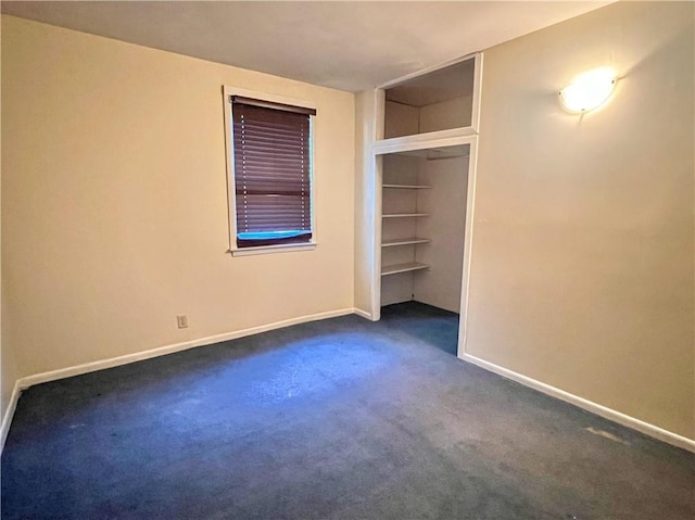 unfurnished bedroom featuring dark colored carpet and baseboards