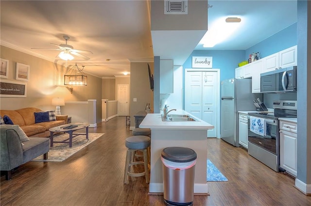 11629 Tomahawk Creek Pkwy Unit G, Leawood, KS 66211 - kitchen featuring stainless steel appliances, a sink, open floor plan, crown molding, and a breakfast bar