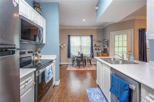 11629 Tomahawk Creek Pkwy Unit G, Leawood, KS 66211 - kitchen featuring appliances with stainless steel finishes, a sink, ornamental molding, white cabinetry, and light countertops