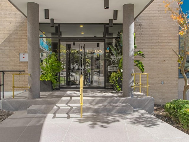 entrance to property featuring brick siding