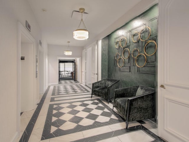 hallway with inlaid floor details, tile patterned floors, and baseboards