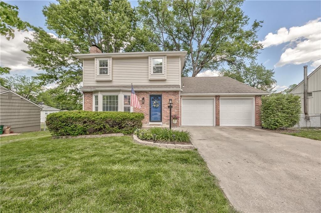 view of front of home with brick siding, a garage, a chimney, concrete driveway, and a front lawn