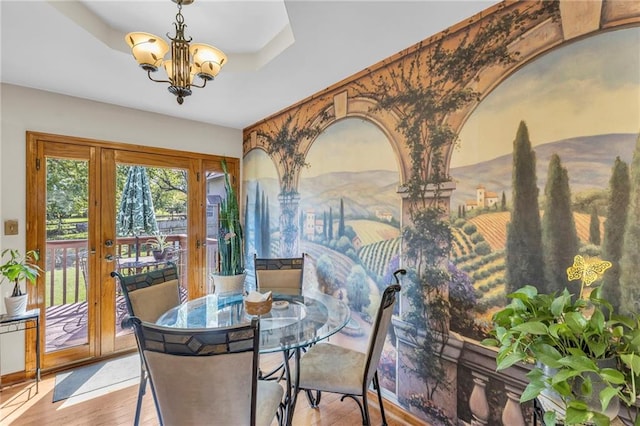 dining room featuring a chandelier, wood finished floors, and french doors