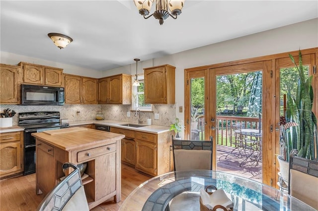 kitchen with black appliances, butcher block counters, a sink, and tasteful backsplash