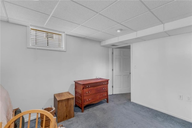 living area featuring carpet flooring, a paneled ceiling, and baseboards
