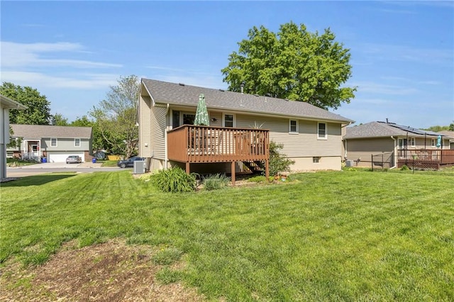 back of house featuring a deck, a lawn, and central AC unit