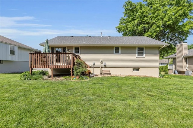 back of property with a deck and a lawn