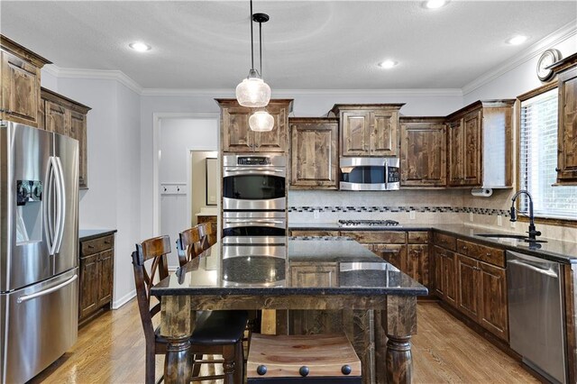 5918 Theden St, Shawnee, KS 66218 - kitchen with appliances with stainless steel finishes, a sink, light wood-style flooring, dark stone counters, and a breakfast bar