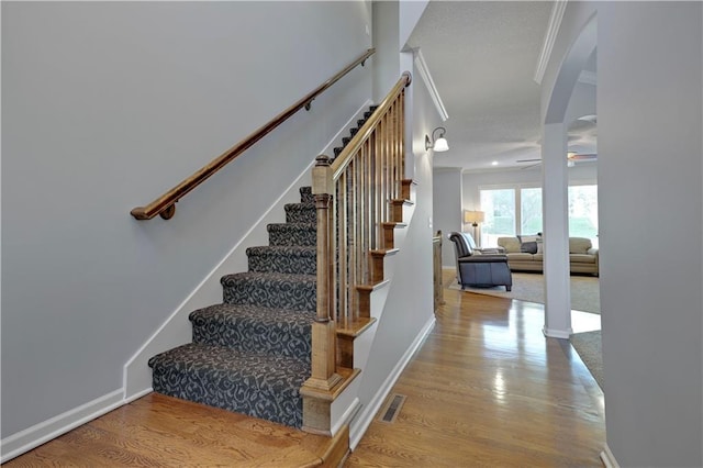5918 Theden St, Shawnee, KS 66218 - stairs with wood finished floors, a ceiling fan, baseboards, crown molding, and arched walkways