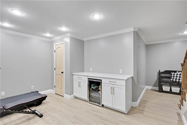 5918 Theden St, Shawnee, KS 66218 - indoor dry bar with wine cooler, light wood-style flooring, a textured ceiling, baseboards, and crown molding