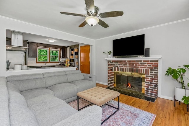 6138 Hadley St, Merriam, KS 66202 - living area featuring a ceiling fan, wood finished floors, crown molding, baseboards, and a fireplace
