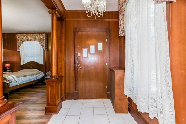 2312 Maple Ave, Leavenworth, KS 66048 - foyer with wooden walls, a chandelier, and light tile patterned floors