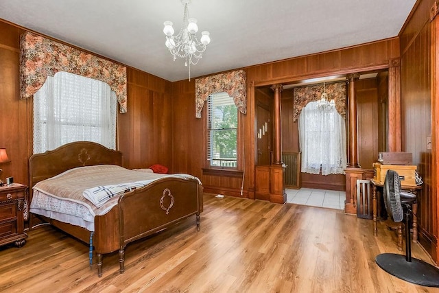 2312 Maple Ave, Leavenworth, KS 66048 - bedroom featuring wood finished floors, wooden walls, and a chandelier