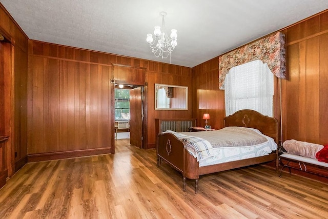 2312 Maple Ave, Leavenworth, KS 66048 - bedroom with a chandelier, wood finished floors, and wood walls