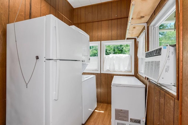 2312 Maple Ave, Leavenworth, KS 66048 - laundry room with healthy amount of natural light, light wood-style flooring, stacked washer and clothes dryer, and wood walls