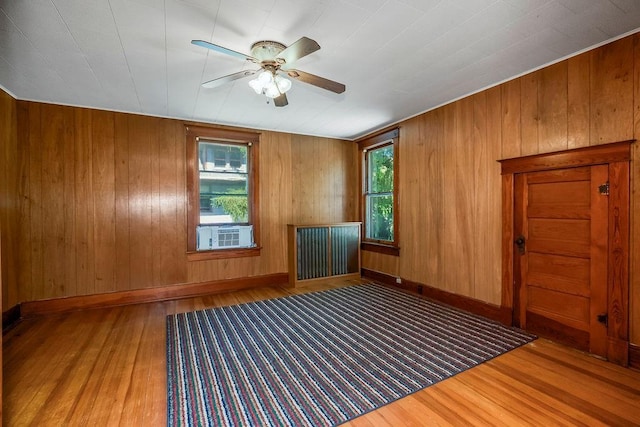 2312 Maple Ave, Leavenworth, KS 66048 - unfurnished room featuring wood finished floors, cooling unit, a ceiling fan, wood walls, and baseboards