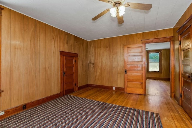 2312 Maple Ave, Leavenworth, KS 66048 - empty room with wood finished floors, ceiling fan, wood walls, and baseboards