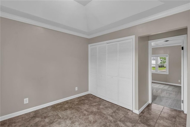 unfurnished bedroom with baseboards, ornamental molding, and a closet