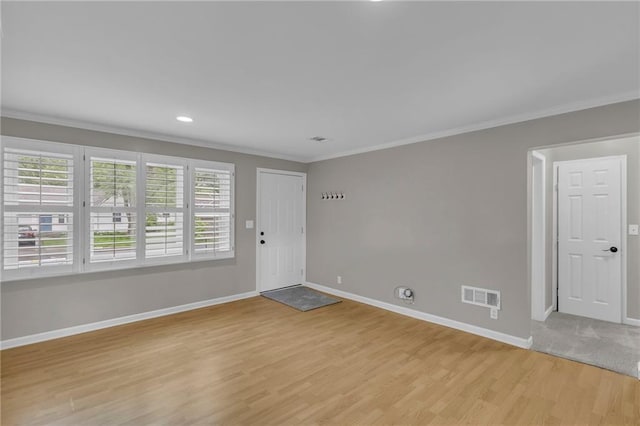 foyer entrance with baseboards, ornamental molding, and visible vents