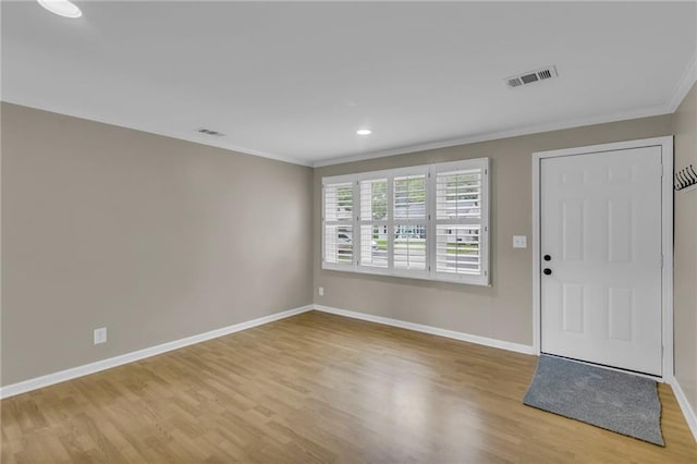 foyer featuring crown molding, visible vents, and wood finished floors