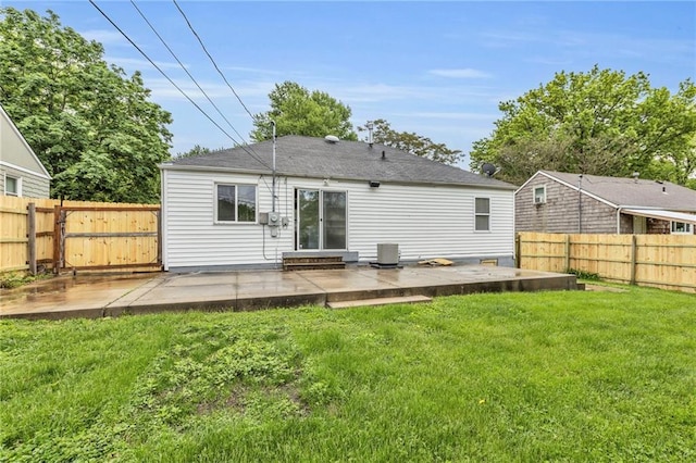 rear view of property featuring a lawn, a fenced backyard, cooling unit, and a patio area