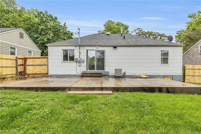 rear view of house featuring a patio, central AC unit, and a yard