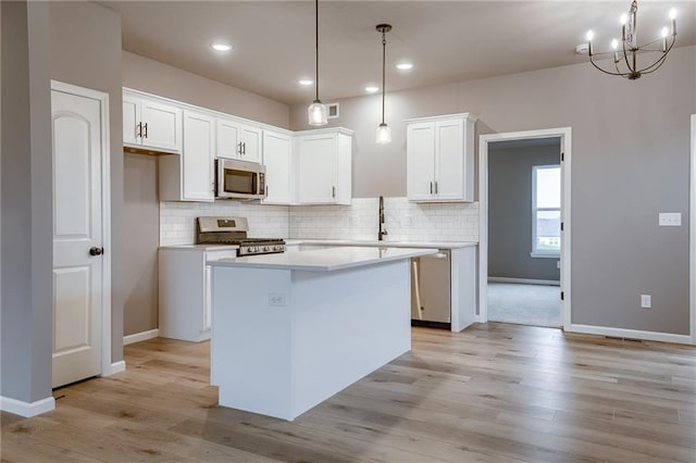 kitchen featuring a kitchen island, stainless steel appliances, white cabinetry, and backsplash