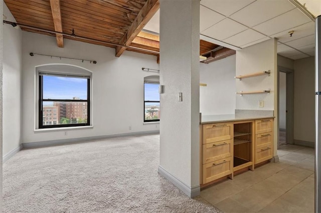 kitchen featuring open shelves, light colored carpet, plenty of natural light, and wood ceiling