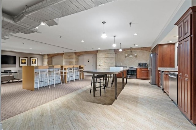 kitchen featuring arched walkways, stainless steel appliances, decorative light fixtures, open floor plan, and recessed lighting
