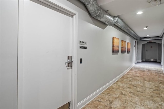 hallway with baseboards and stone finish flooring