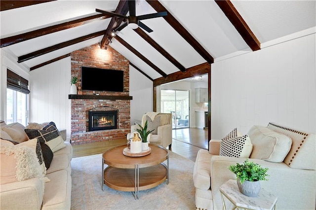 living area with wood finished floors, a fireplace, and a ceiling fan