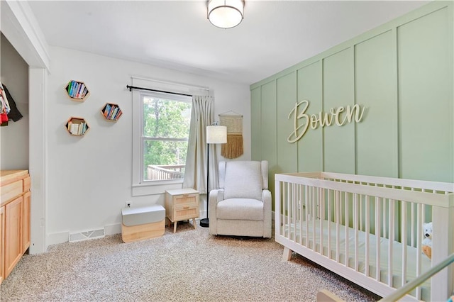bedroom with carpet floors, a crib, and baseboards