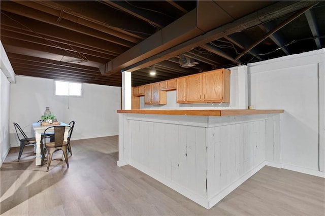 basement featuring light wood-style floors and baseboards