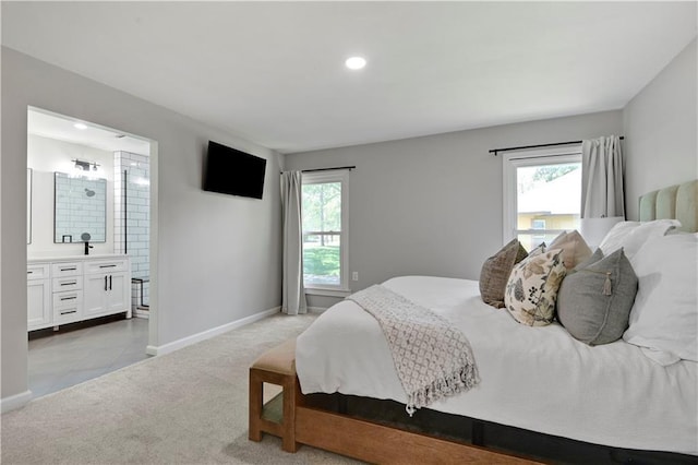 carpeted bedroom featuring multiple windows, baseboards, recessed lighting, and ensuite bathroom