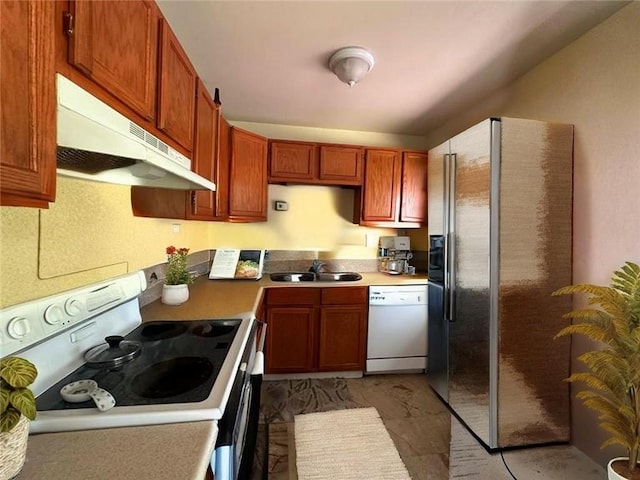 4714 Norton Ave, Kansas City, MO 64130 - kitchen featuring white appliances, a sink, under cabinet range hood, light countertops, and brown cabinetry