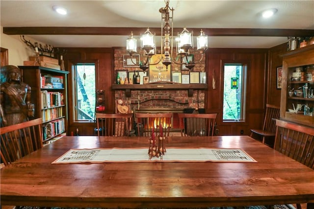 12 Woodland Trl, Warrensburg, MO 64093 - dining area featuring a brick fireplace, wooden walls, a chandelier, and beamed ceiling
