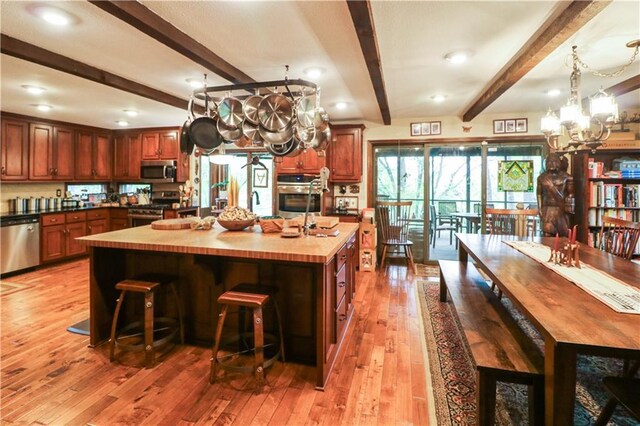 12 Woodland Trl, Warrensburg, MO 64093 - kitchen featuring stainless steel appliances, a chandelier, light wood-style floors, beamed ceiling, and a spacious island