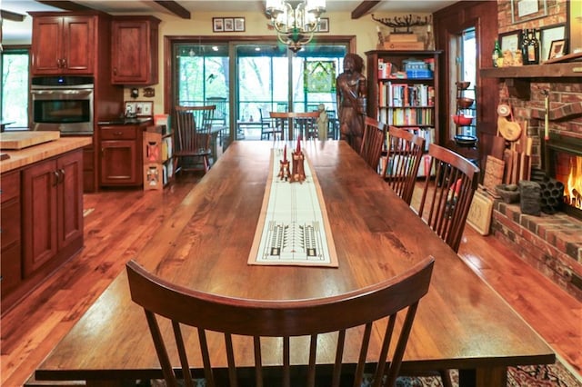 12 Woodland Trl, Warrensburg, MO 64093 - dining area with dark wood-style flooring, a brick fireplace, and a chandelier