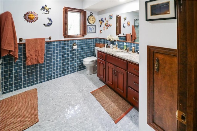 12 Woodland Trl, Warrensburg, MO 64093 - bathroom with vanity, tile walls, toilet, and wainscoting