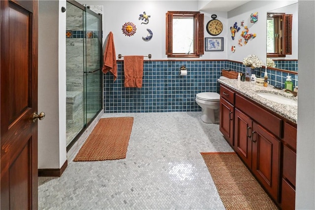 12 Woodland Trl, Warrensburg, MO 64093 - full bathroom with a stall shower, vanity, toilet, tile walls, and a wainscoted wall