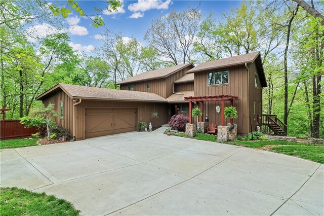 12 Woodland Trl, Warrensburg, MO 64093 - view of front of home featuring an attached garage, driveway, and a shingled roof
