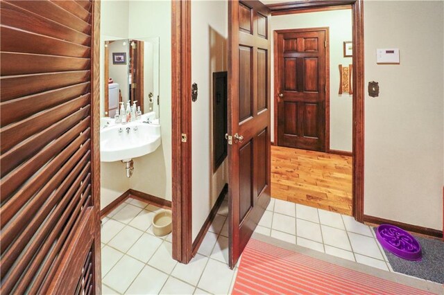 12 Woodland Trl, Warrensburg, MO 64093 - corridor with light tile patterned flooring, baseboards, and a sink
